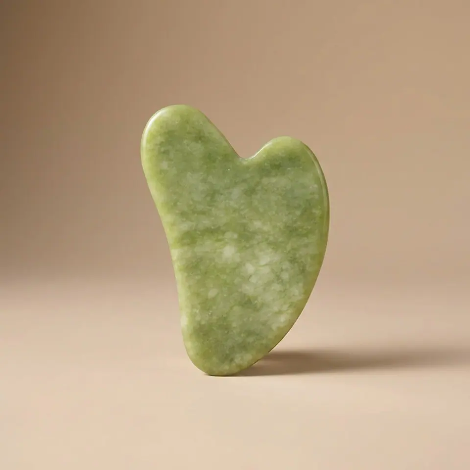 Jade roller resting on a linen surface